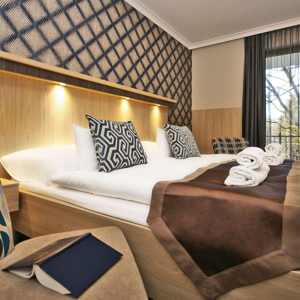 Divina Boutique Hotel Harkány - szoba részlet franciaággyal és hímzett törölközőkkel, díszpárnákkal